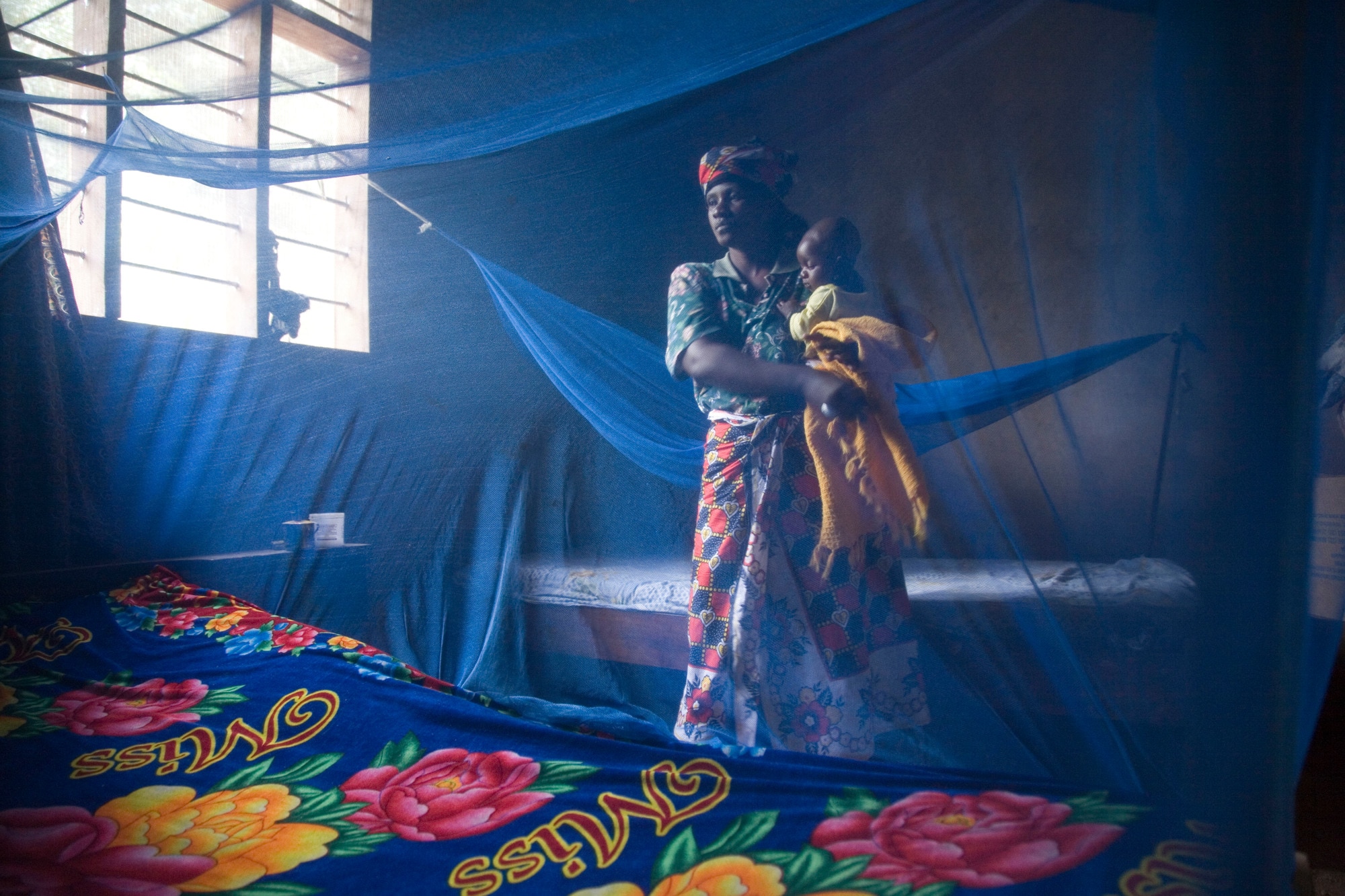 A long-lasting insecticide-treated mosquito bed net hangs in a woman’s home in Ifakara, Tanzania.