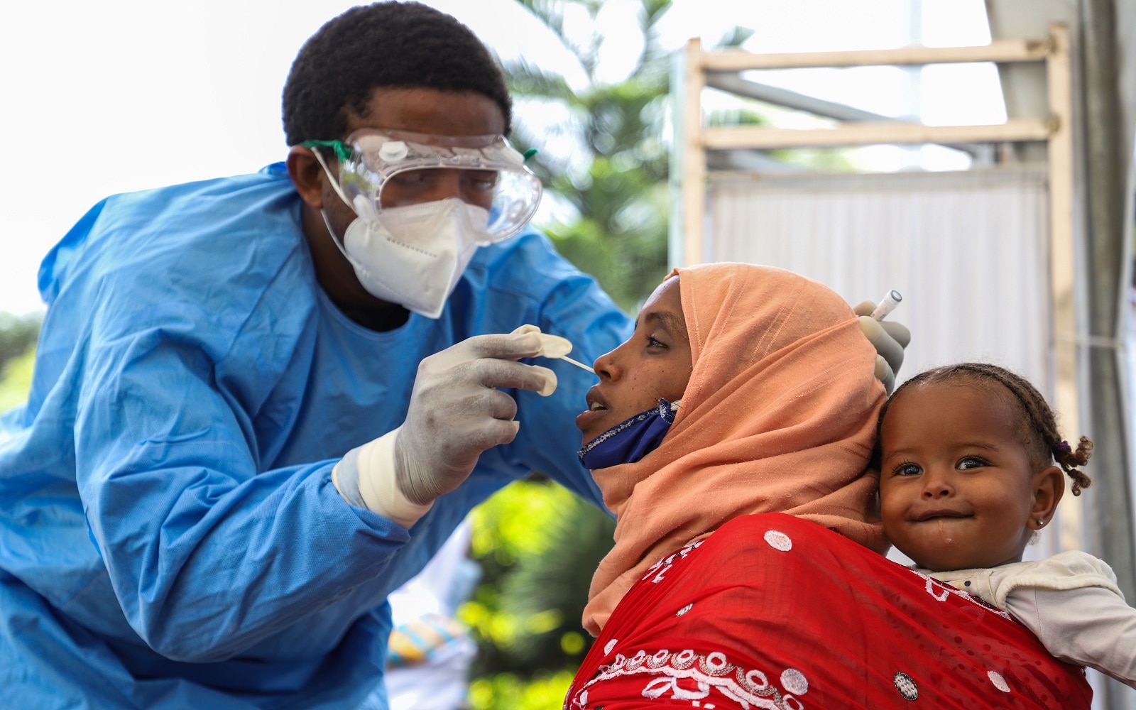 A medical worker collects a swab sample from a mother for COVID-19 tests at a hospital in Addis Ababa, Ethiopia, Aug.16, 2020.