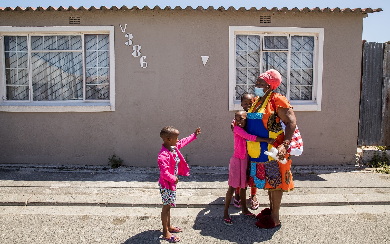 Woman is greeted by her grandchildren as she arrives at her house in Cape Town, South Africa.